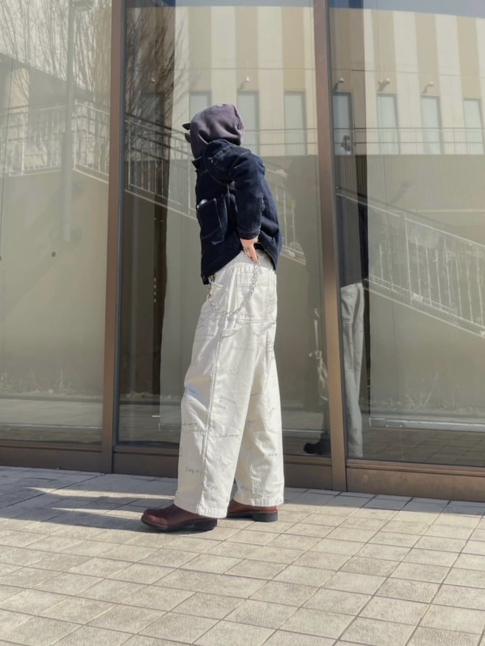 ブラウン系のブーツ、ホワイト系のチノパンツ、ベージュ系のキャップを着用したメンズの春コーディネートの2枚目の写真