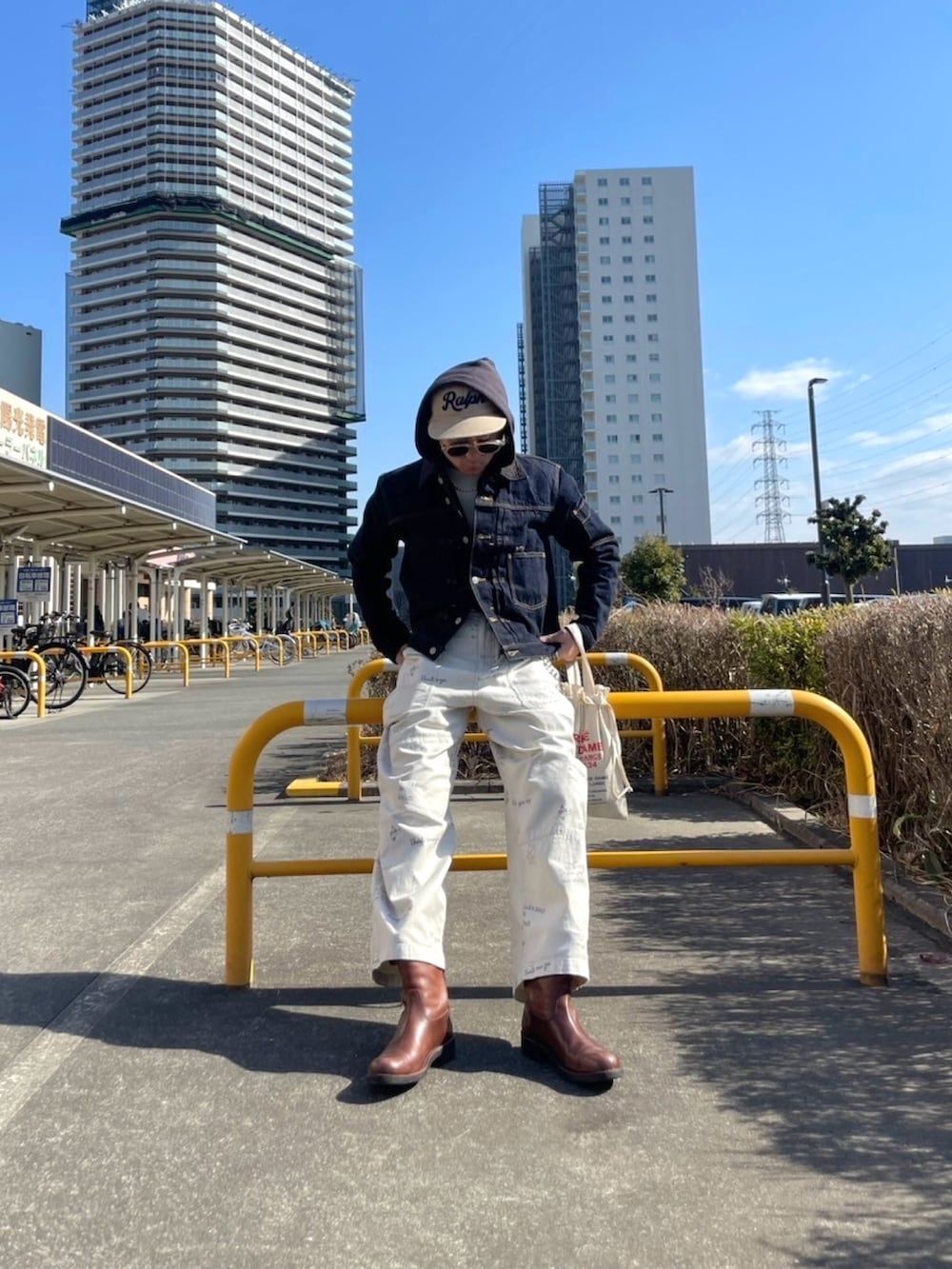 ブラウン系のブーツ、ホワイト系のチノパンツ、ベージュ系のキャップを着用したメンズの春コーディネートの3枚目の写真