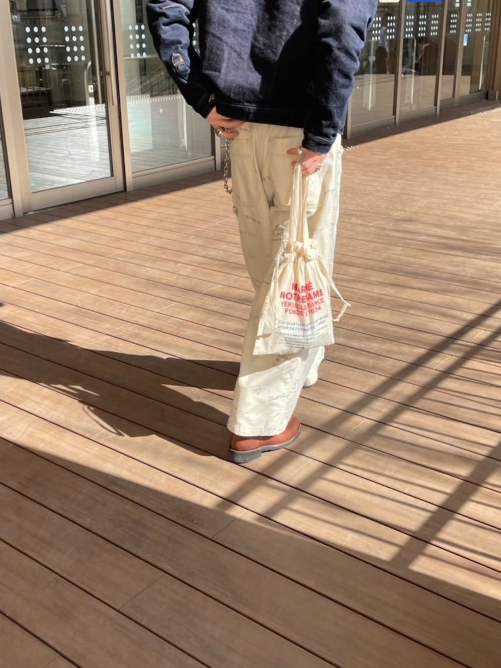 ブラウン系のブーツ、ホワイト系のチノパンツ、ベージュ系のキャップを着用したメンズの春コーディネートの4枚目の写真