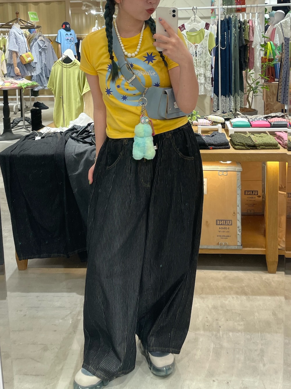 イエロー系のTシャツ/カットソー、グレー系のデニムパンツ、ブルー系のベルトを着用したレディースの夏コーディネートの2枚目の写真