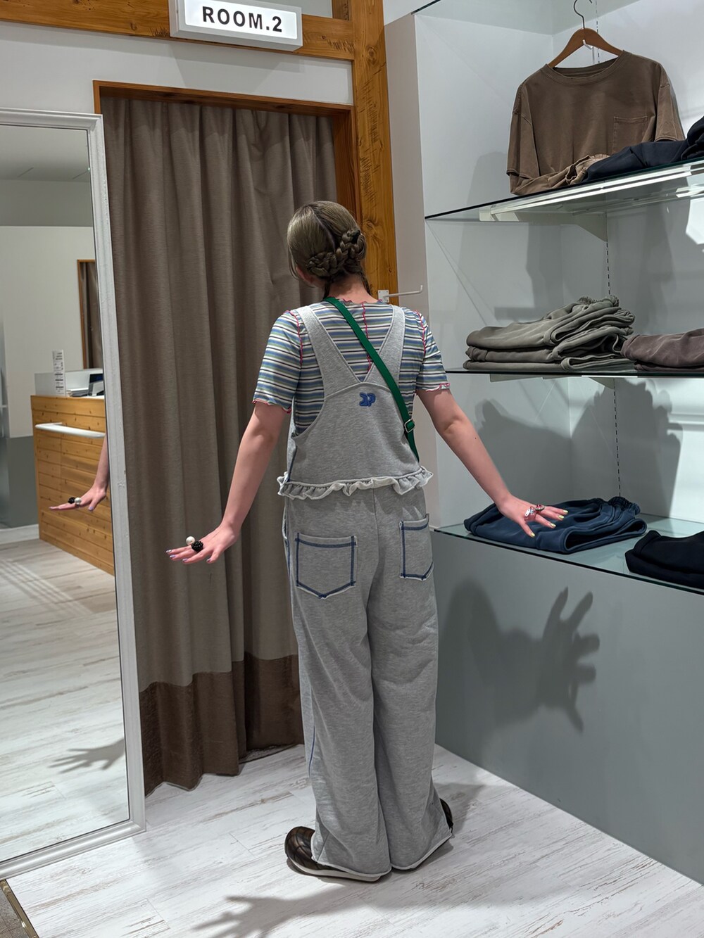 グリーン系のショルダーバッグ、グリーン系のTシャツ/カットソー、グレー系のサロペット/オーバーオールを着用したレディースの夏コーディネートの2枚目の写真