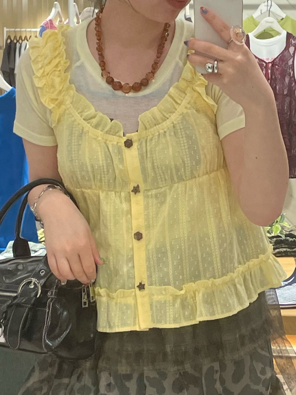 イエロー系のシャツ/ブラウス、ホワイト系のTシャツ/カットソー、グリーン系のスカートを着用したレディースの夏コーディネートの2枚目の写真