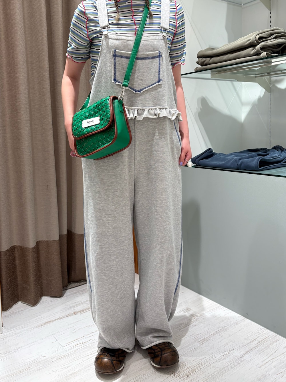 グリーン系のショルダーバッグ、グリーン系のTシャツ/カットソー、グレー系のサロペット/オーバーオールを着用したレディースの夏コーディネートの5枚目の写真