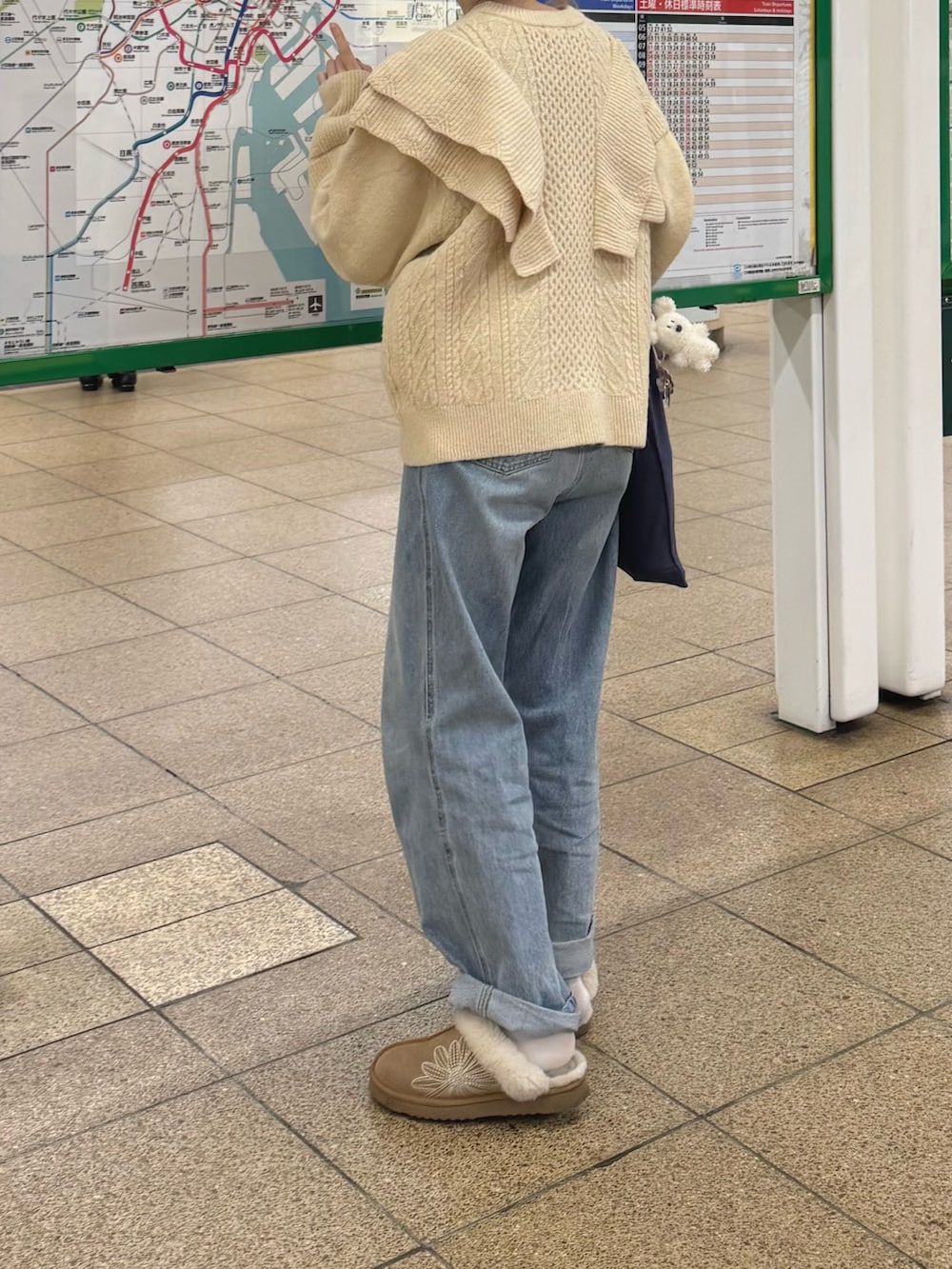 ベージュ系のニット/セーター、ブルー系のデニムパンツ、ブラウン系のスリッポンを着用したレディースの冬コーディネートの2枚目の写真