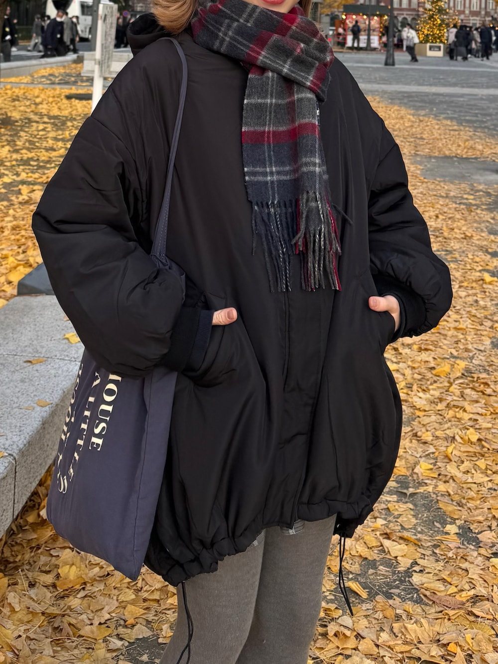 ブラック系のダウンジャケット/コート、ブラウン系のスニーカー、ブルー系のトートバッグを着用したレディースの冬コーディネートの3枚目の写真