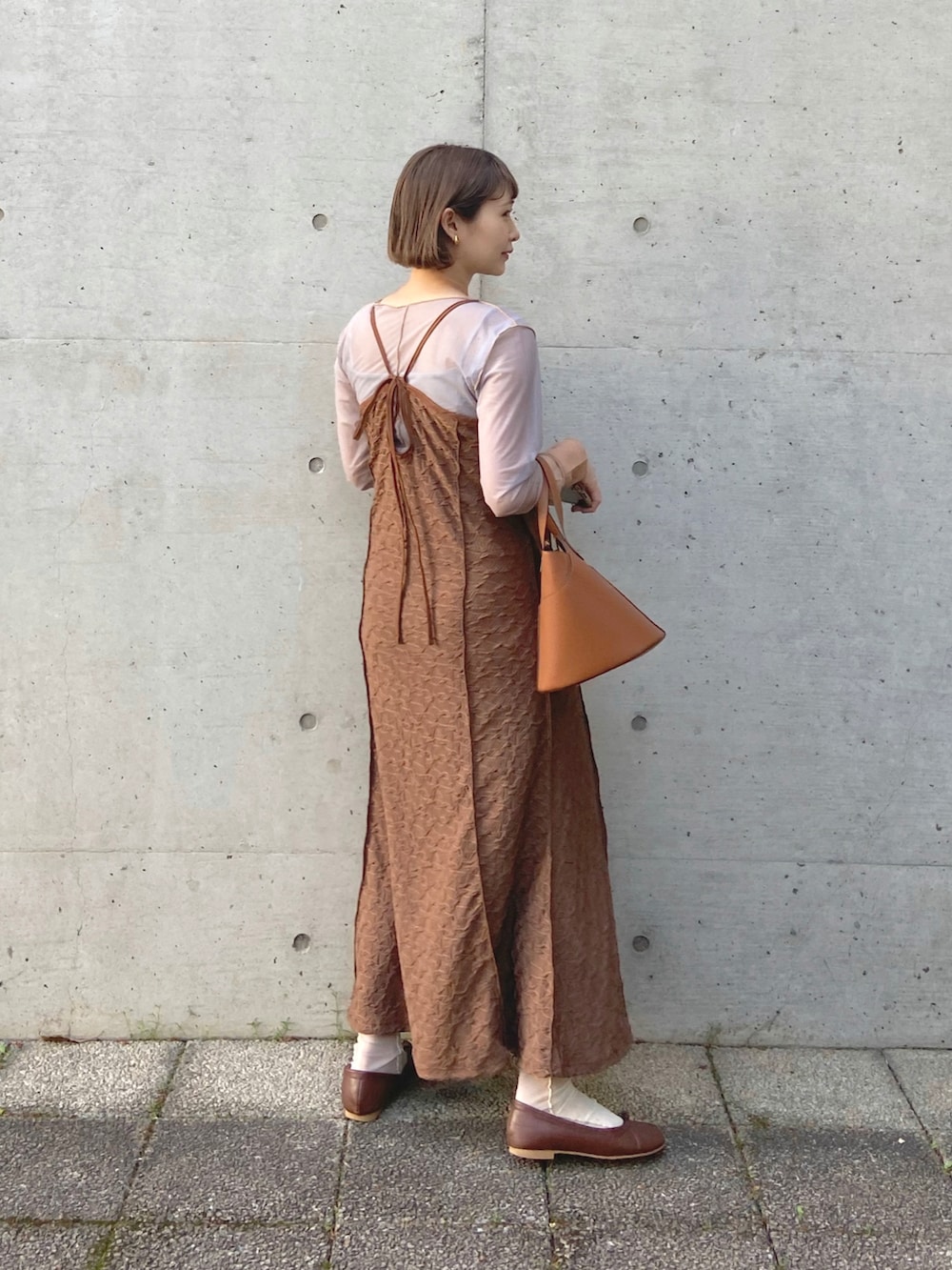ホワイト系のTシャツ/カットソー、ブラウン系のワンピース、ブラウン系のハンドバッグを着用したレディースの春コーディネートの2枚目の写真