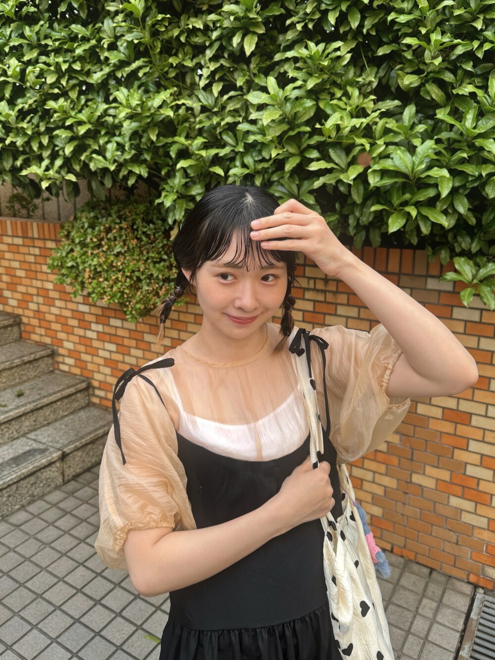 オレンジ系のシャツ/ブラウス、ブラック系のワンピース、その他のトートバッグを着用したレディースの春コーディネートの4枚目の写真