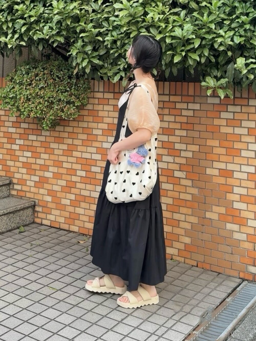 オレンジ系のシャツ/ブラウス、ブラック系のワンピース、その他のトートバッグを着用したレディースの春コーディネートの3枚目の写真