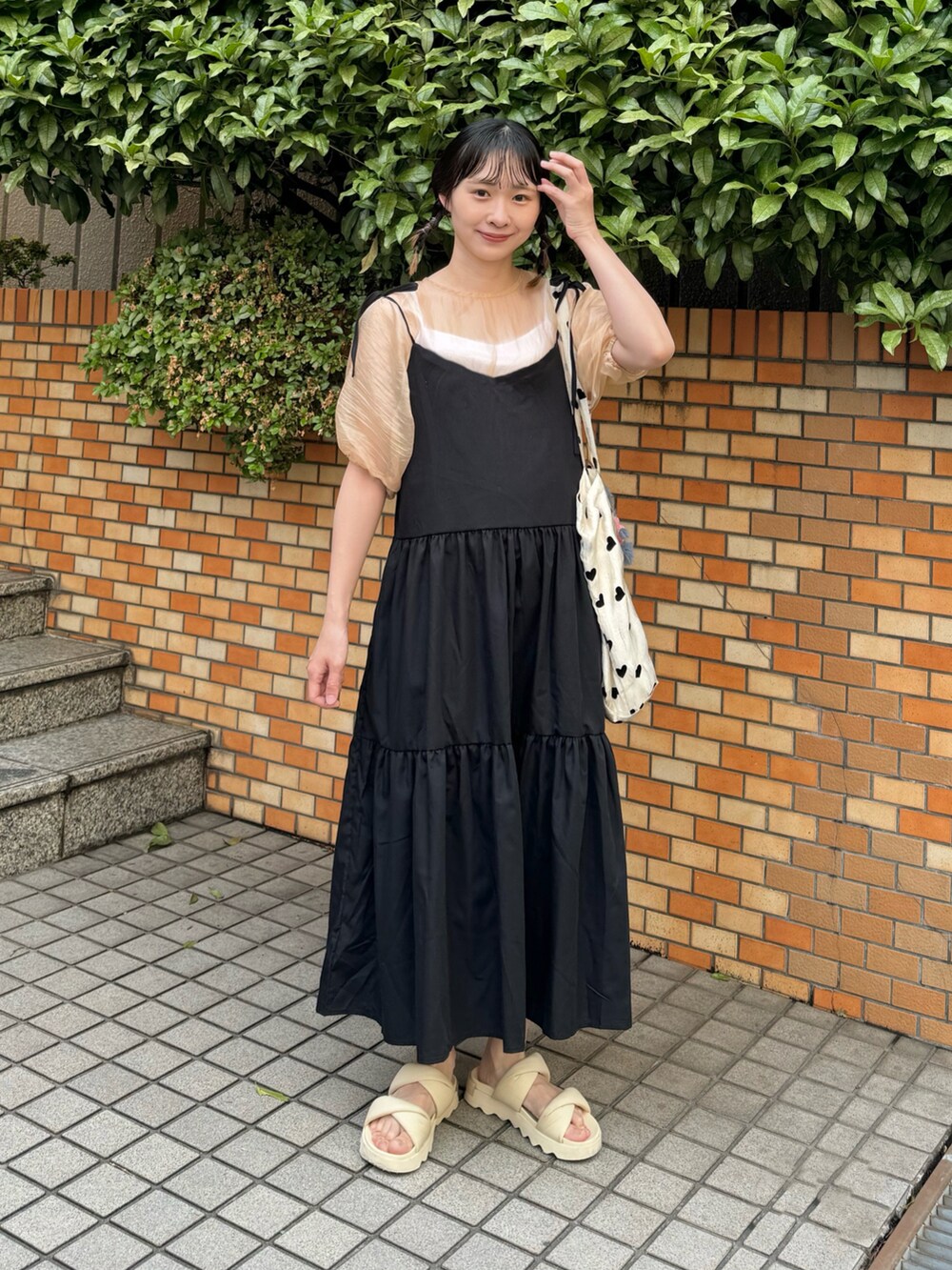 オレンジ系のシャツ/ブラウス、ブラック系のワンピース、その他のトートバッグを着用したレディースの春コーディネートの2枚目の写真