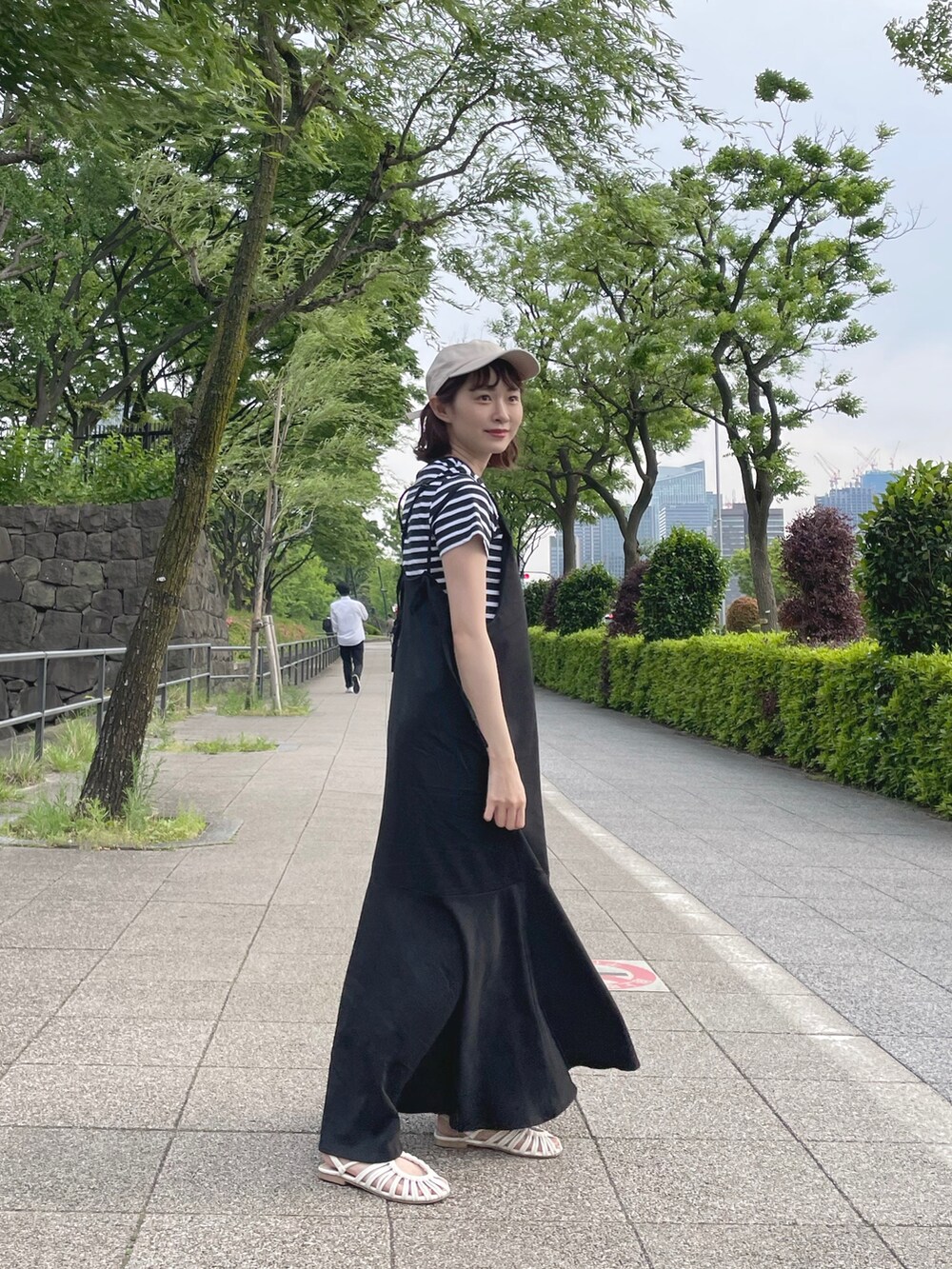 ブラック系のTシャツ/カットソー、ブラック系のワンピース、ホワイト系のサンダルを着用したレディースの春コーディネートの2枚目の写真