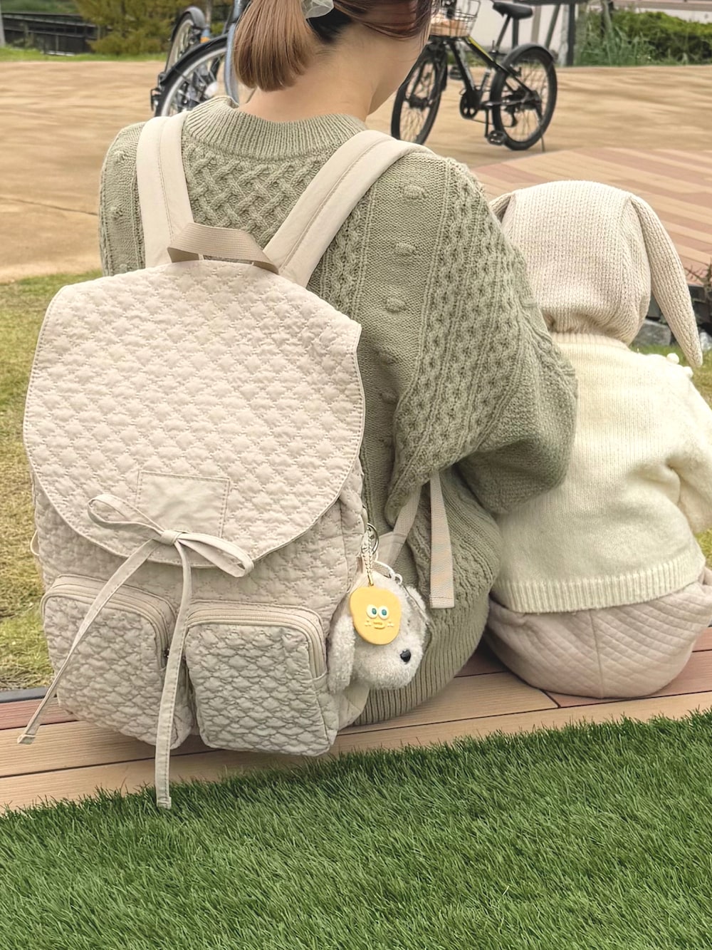 ホワイト系のスニーカー、ホワイト系のバックパック/リュック、ホワイト系のその他ベビーウェアを着用したレディースの秋コーディネートの2枚目の写真