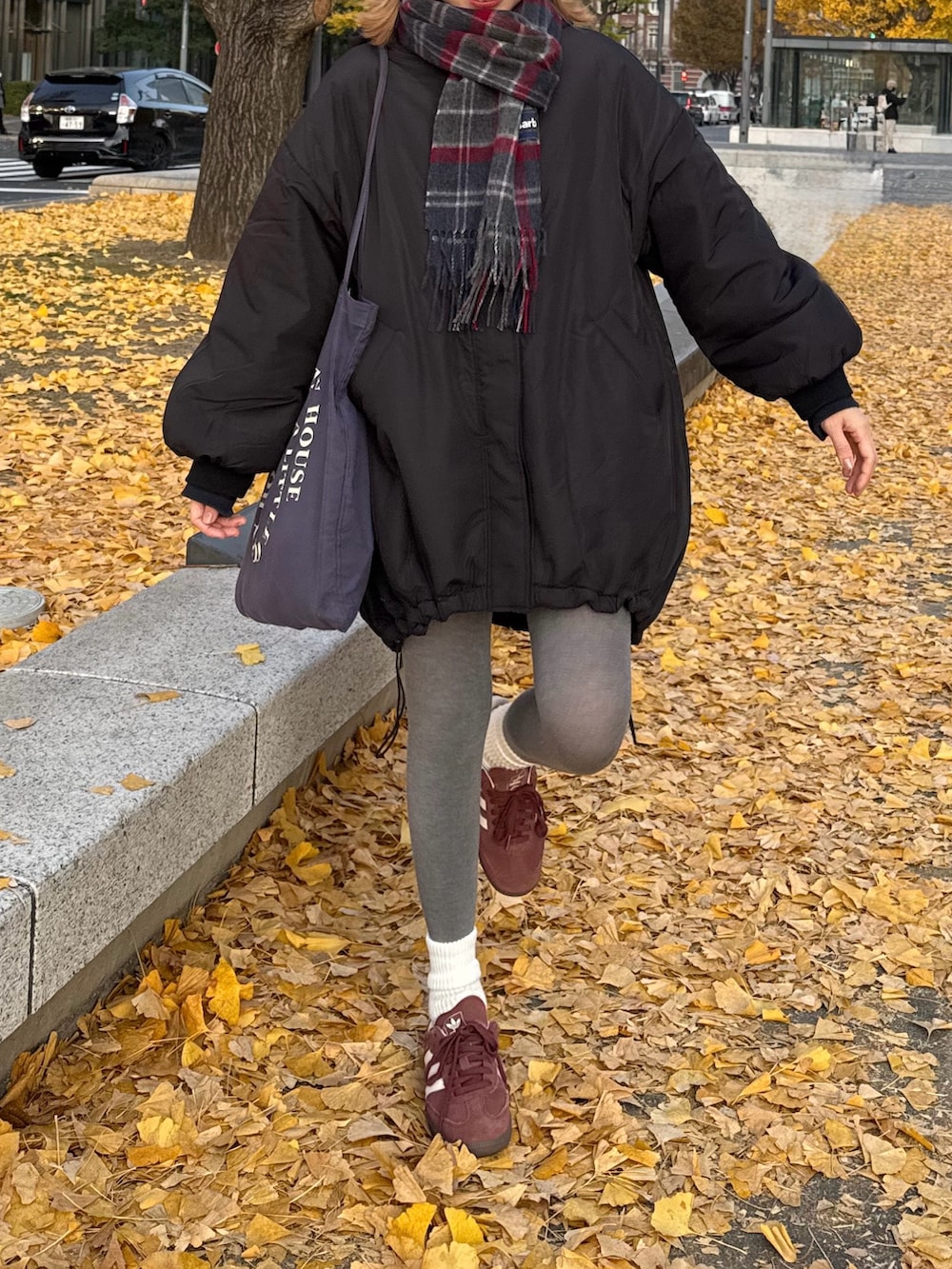 ブラック系のダウンジャケット/コート、ブラウン系のスニーカー、ブルー系のトートバッグを着用したレディースの冬コーディネートの4枚目の写真