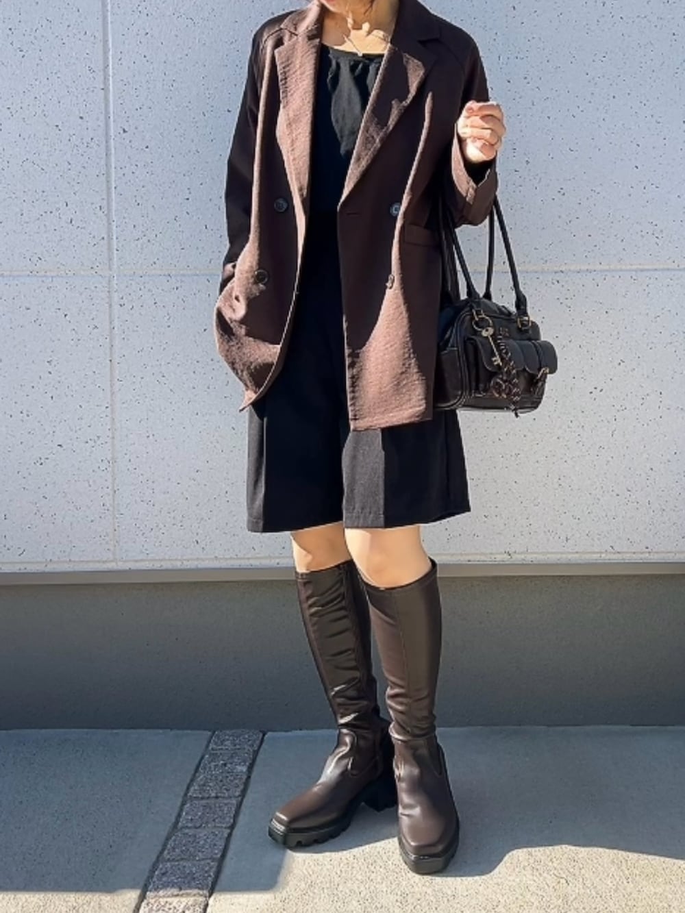 ブラウン系のブーツ、ブラック系のその他パンツ、ブラウン系のジャケット/アウターを着用したレディースの秋コーディネートの2枚目の写真