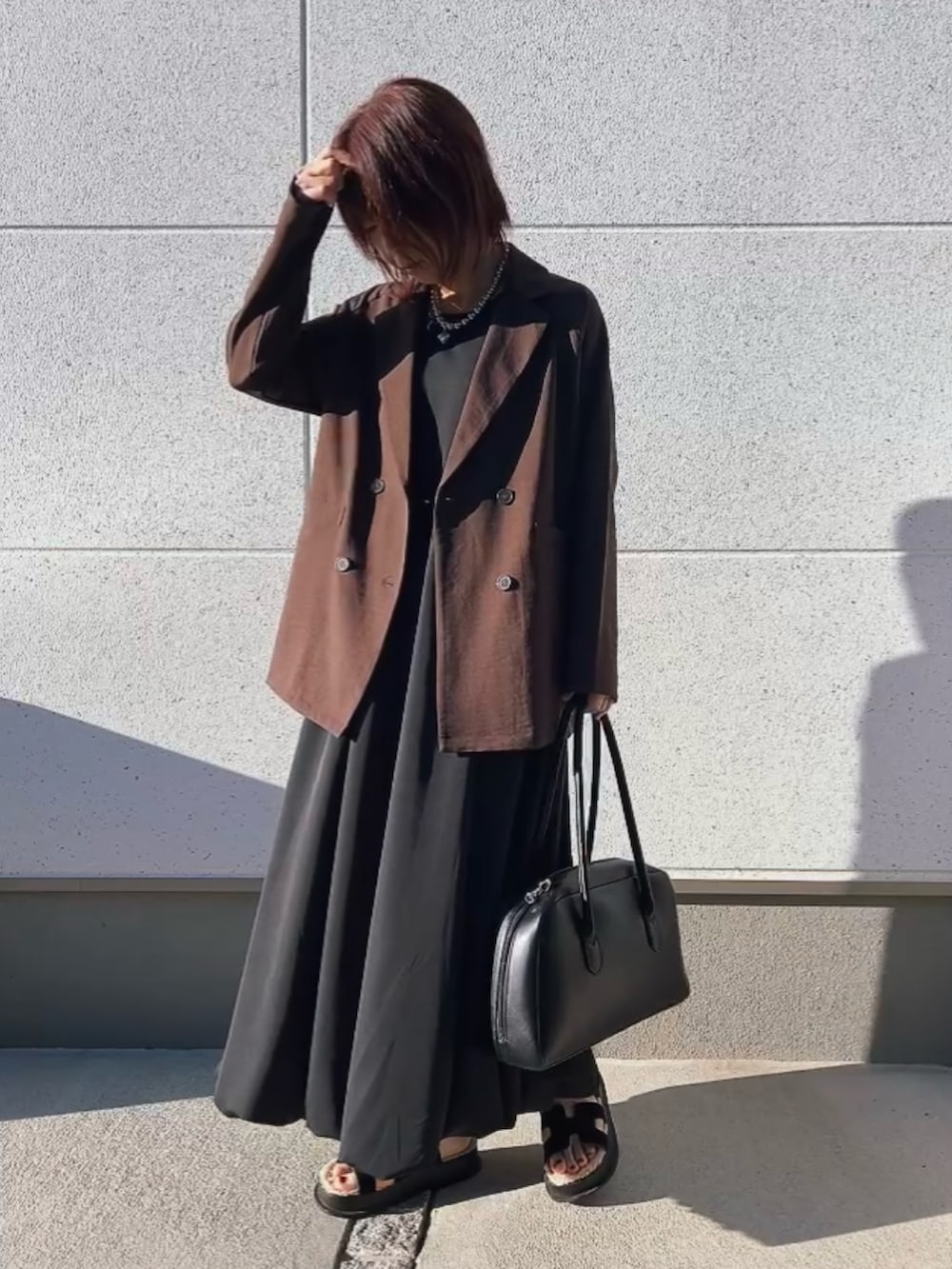 ブラウン系のジャケット/アウター、ブラック系のワンピース/ドレス、ブラック系のバッグを着用したレディースの秋コーディネートの3枚目の写真