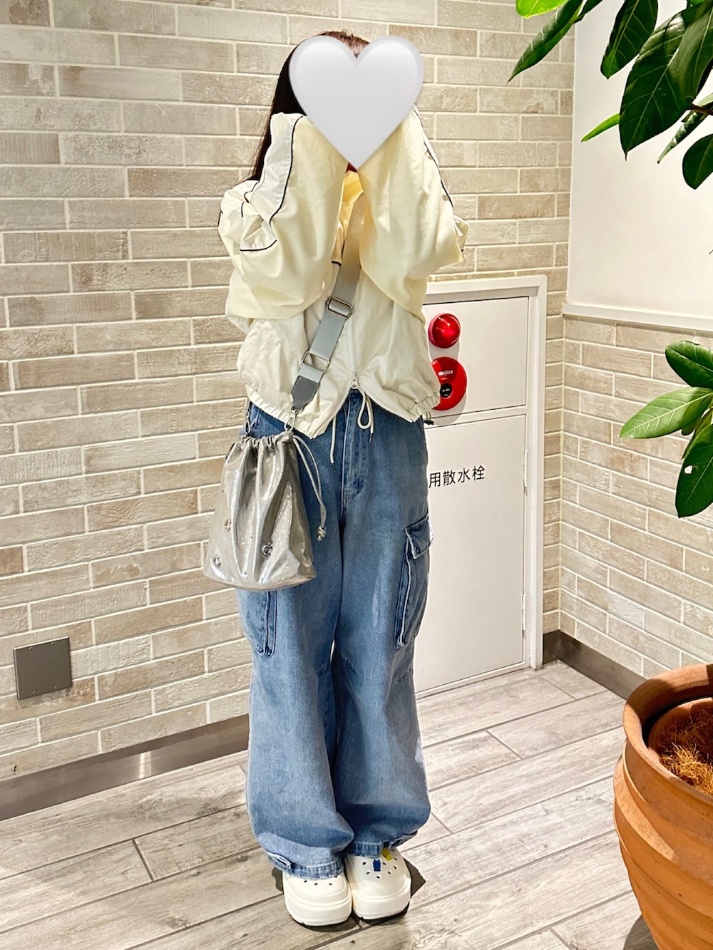 ホワイト系のブルゾン、シルバー系のショルダーバッグ、ブルー系のデニムパンツを着用したレディースの春コーディネートの2枚目の写真