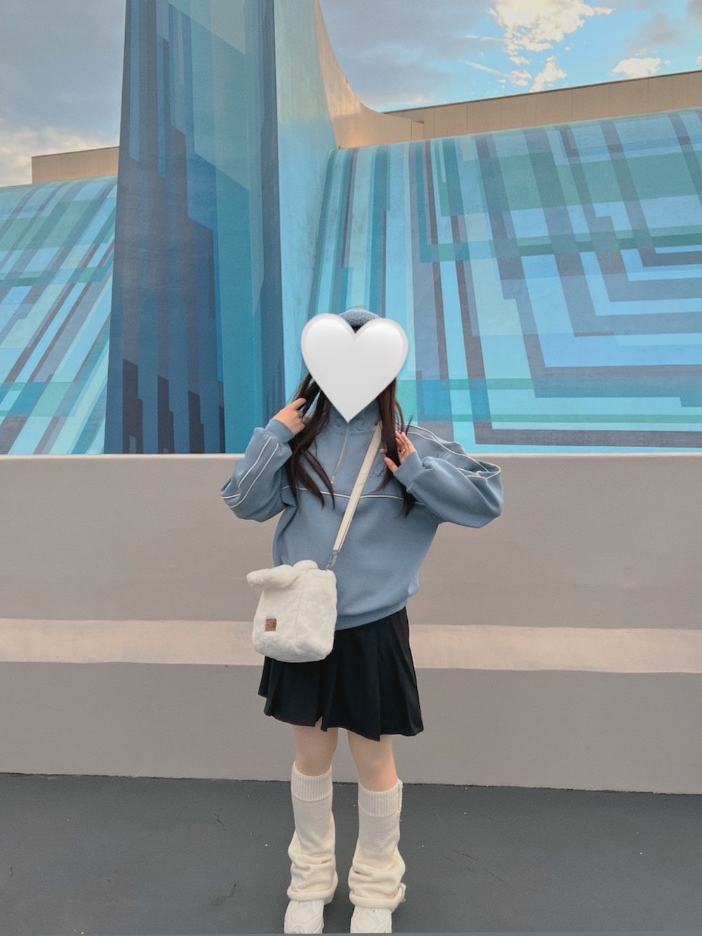 ブルー系のスウェット、ブラック系のスカート、ベージュ系のスニーカーを着用したレディースの冬コーディネートの2枚目の写真