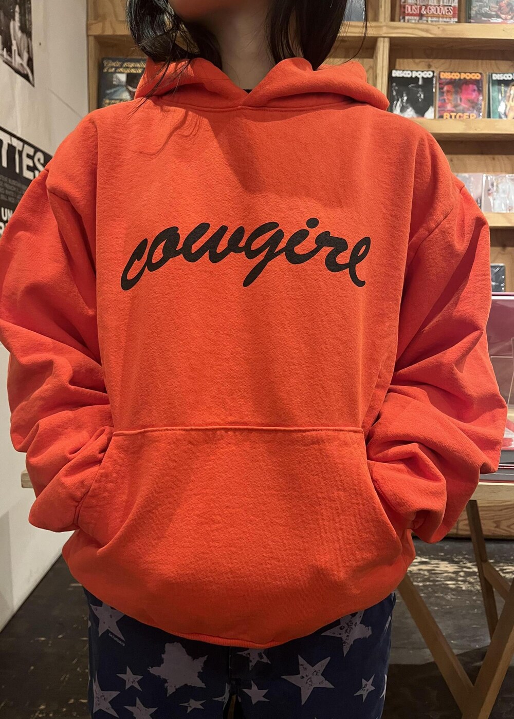 オレンジ系のパーカーを着用したレディースの冬コーディネートの2枚目の写真