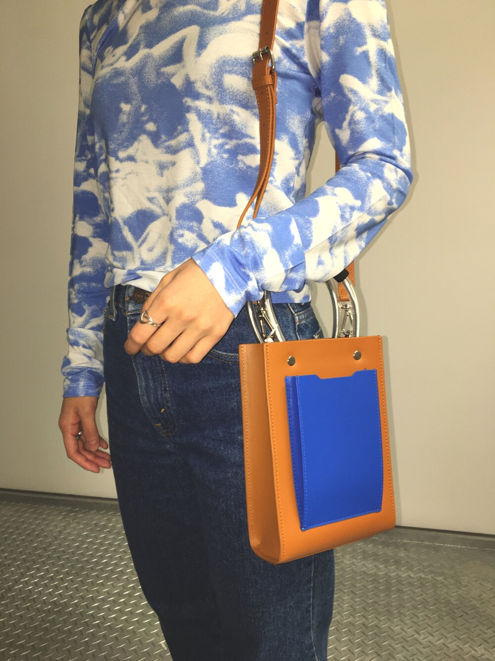 ブルー系のTシャツ/カットソー、ブラウン系のバッグを着用したレディースの秋コーディネートの4枚目の写真