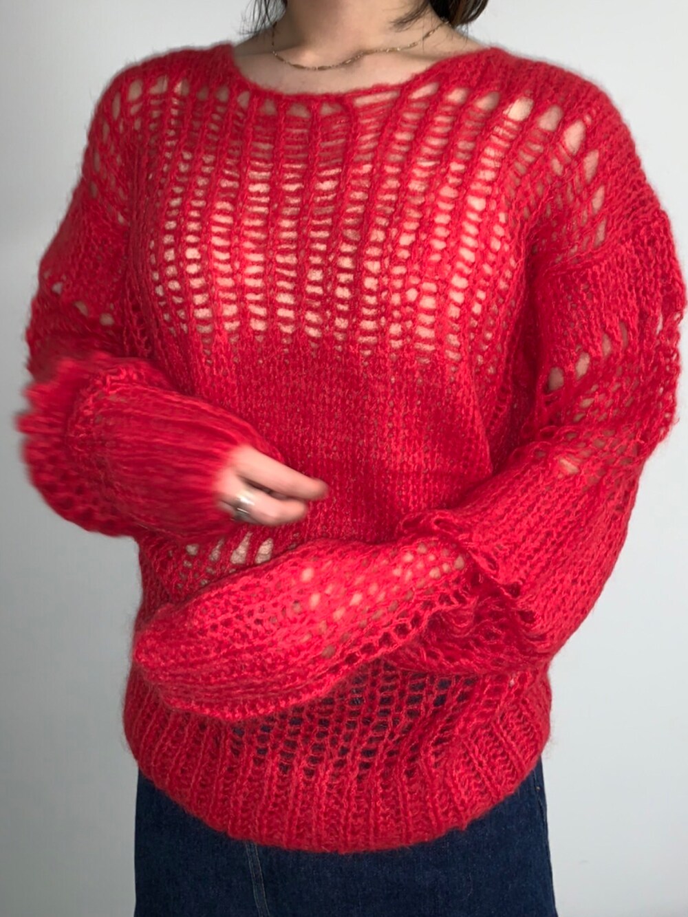 レッド系のニット/セーター、ブルー系のニットキャップ/ビーニーを着用したレディースの秋コーディネートの3枚目の写真