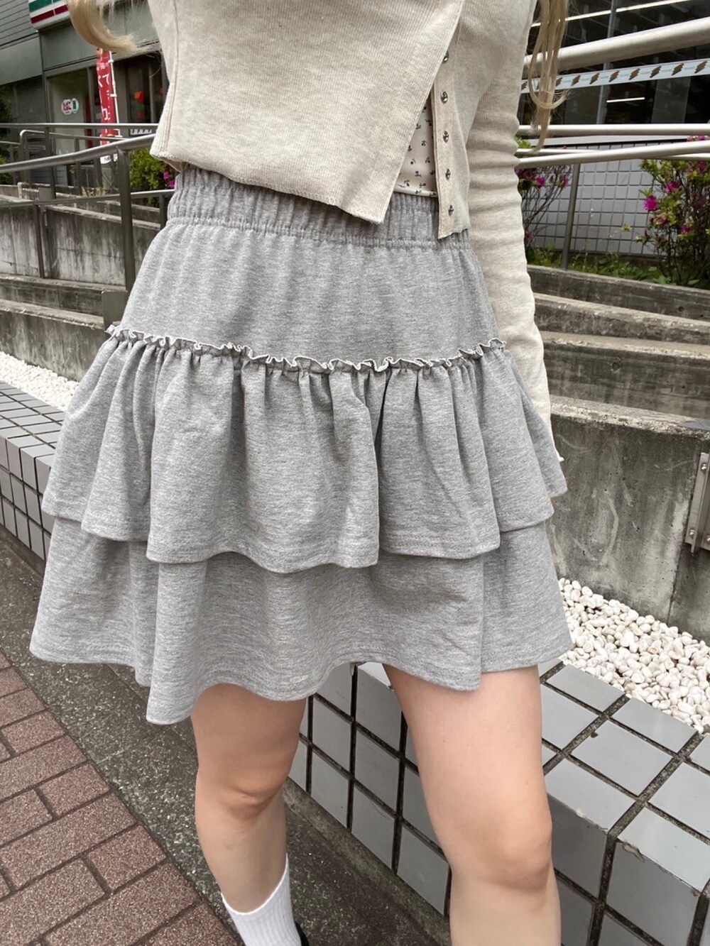 ホワイト系のTシャツ/カットソー、グレー系のスカート、ブラック系のショルダーバッグを着用したレディースの春コーディネートの5枚目の写真