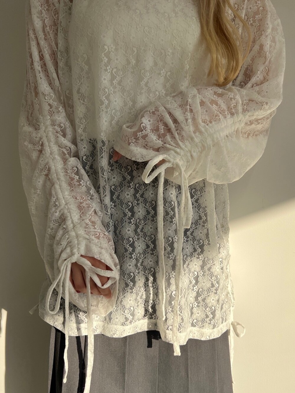 ホワイト系のTシャツ/カットソー、グレー系のスカート、ブルー系のキャップを着用したレディースの春コーディネートの3枚目の写真