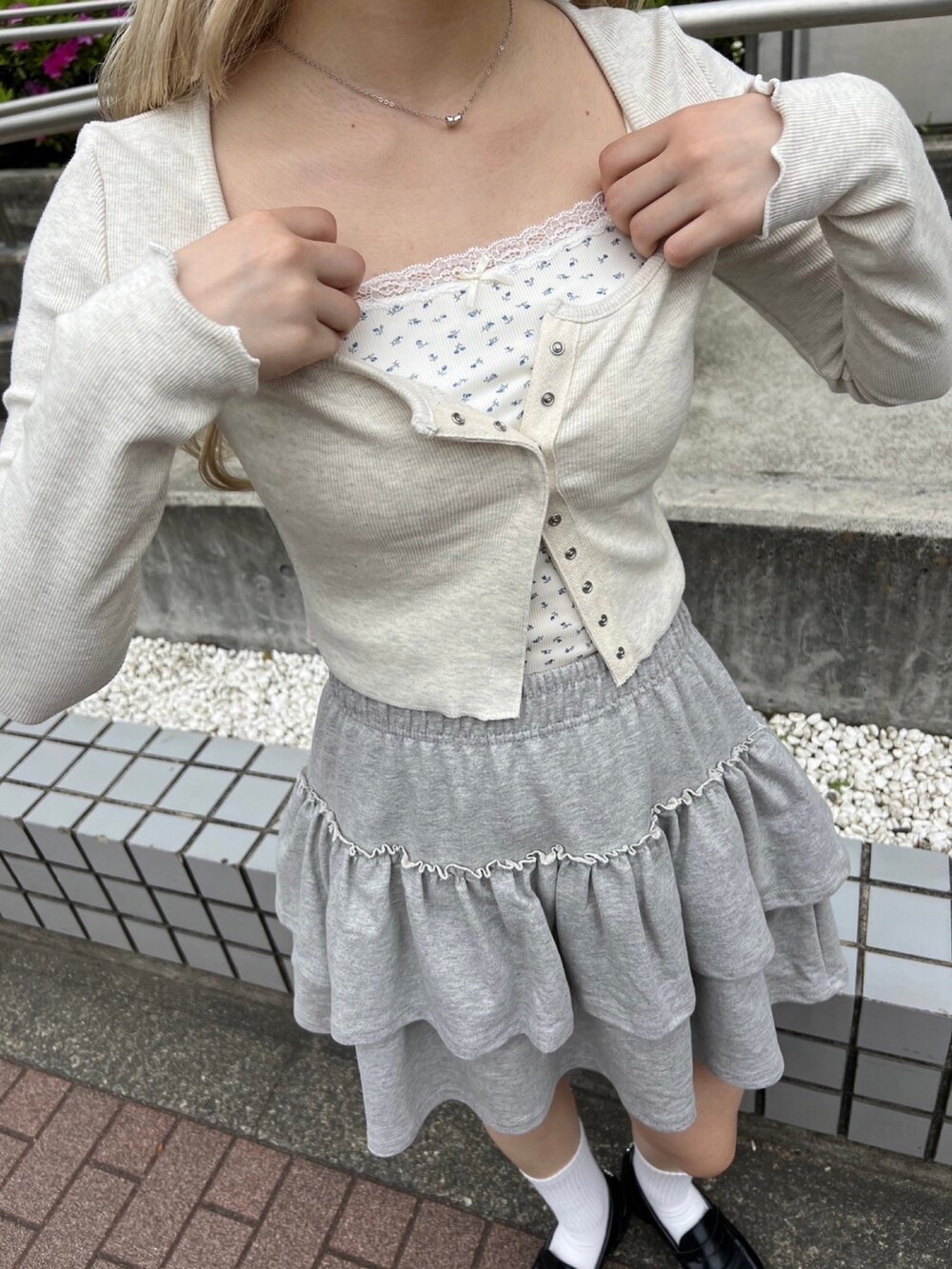 ホワイト系のTシャツ/カットソー、グレー系のスカート、ブラック系のショルダーバッグを着用したレディースの春コーディネートの4枚目の写真