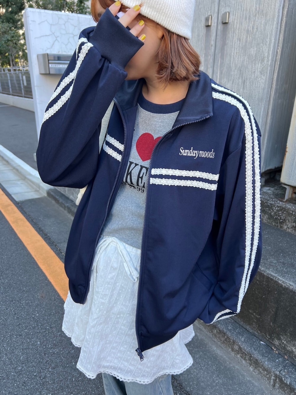 ブルー系のジャージ、ホワイト系のスカート、ブルー系のデニムパンツを着用したレディースの冬コーディネートの2枚目の写真