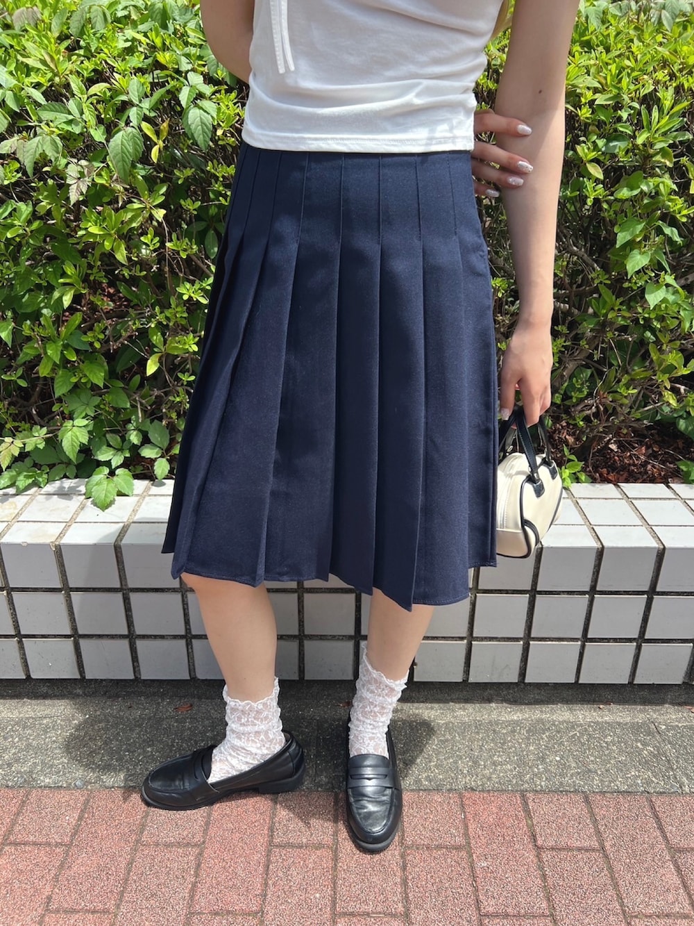 ブルー系のスカート、ホワイト系のTシャツ/カットソー、ホワイト系のソックス/靴下を着用したレディースの夏コーディネートの3枚目の写真