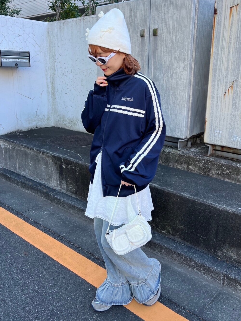 ブルー系のジャージ、ホワイト系のスカート、ブルー系のデニムパンツを着用したレディースの冬コーディネートの3枚目の写真