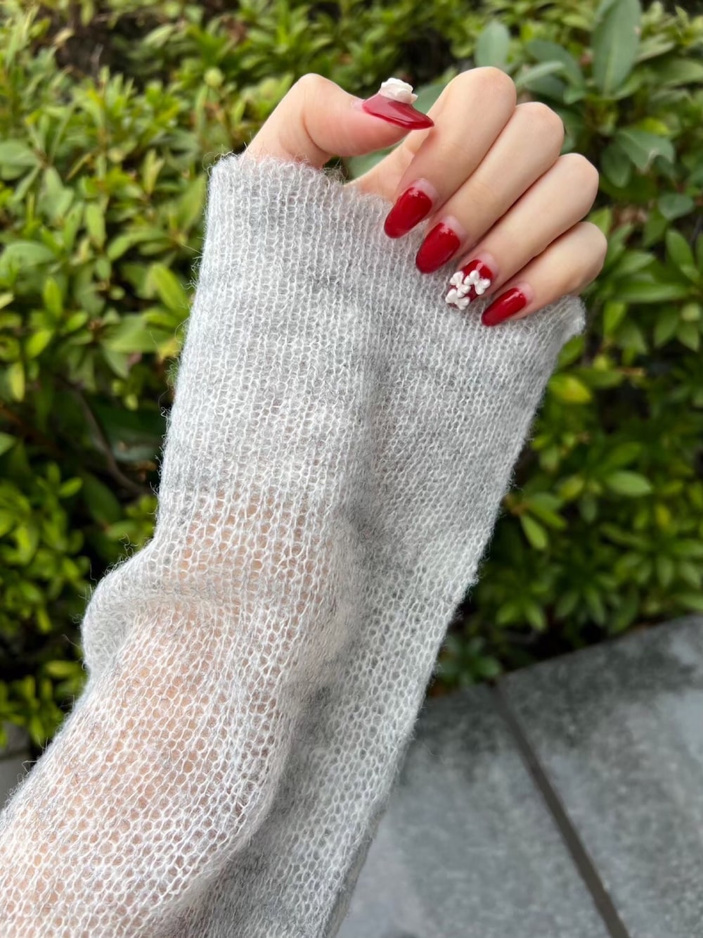 グレー系のニット/セーター、ホワイト系のスカート、ブルー系のデニムパンツを着用したレディースの冬コーディネートの5枚目の写真