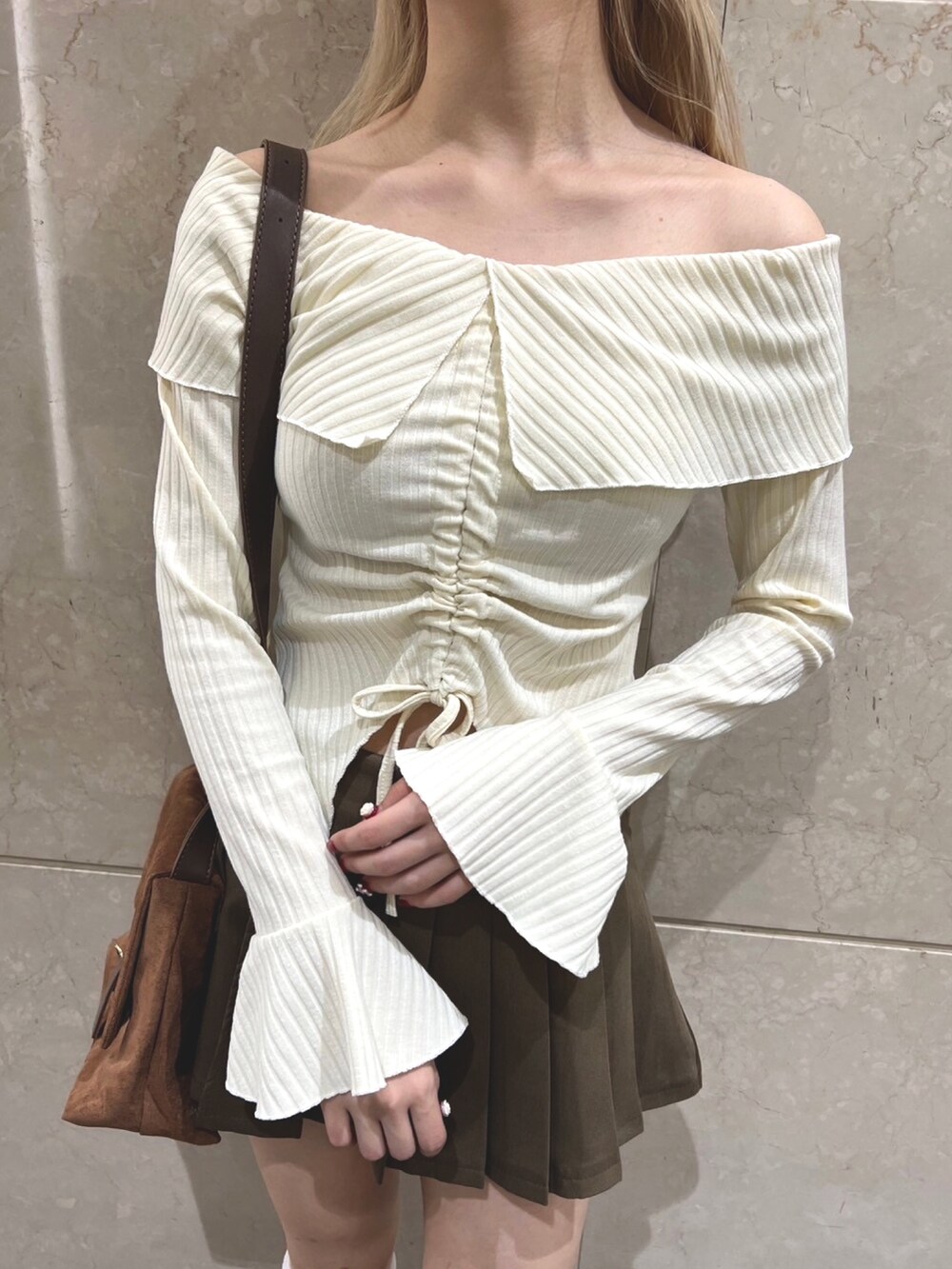 ベージュ系のスカート、ホワイト系のTシャツ/カットソーを着用したレディースの冬コーディネートの2枚目の写真
