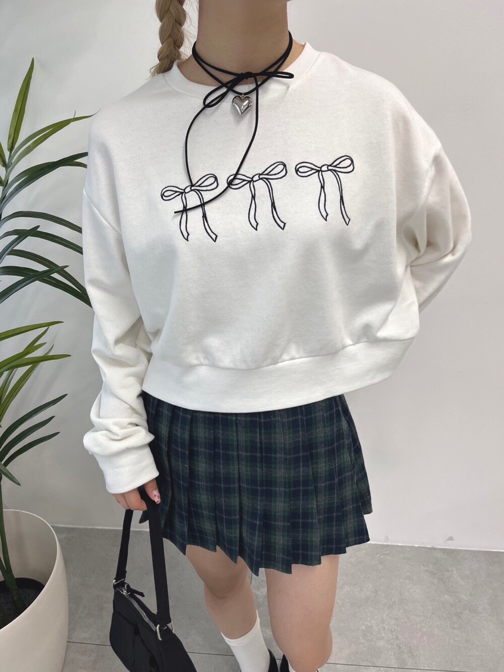 ホワイト系のスウェット、グリーン系のスカートを着用したレディースの秋コーディネートの2枚目の写真