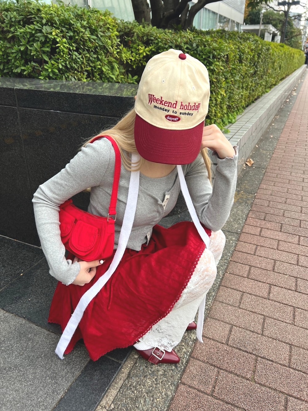 ホワイト系のその他パンツ、レッド系のスカート、グレー系のTシャツ/カットソーを着用したレディースの冬コーディネートの3枚目の写真