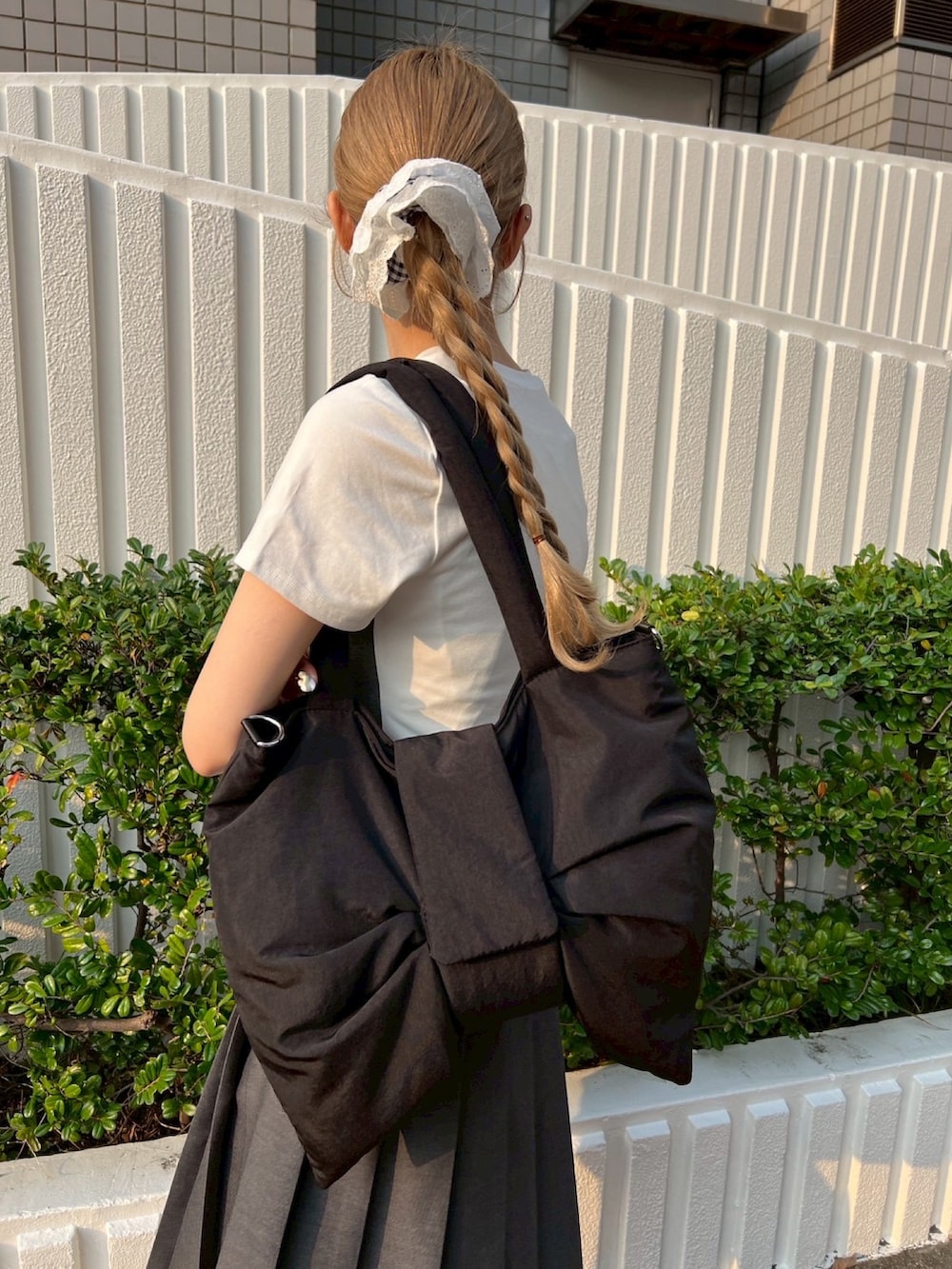 グレー系のTシャツ/カットソー、ブラック系のショルダーバッグ、ブラック系のシュシュを着用したレディースの春コーディネートの7枚目の写真