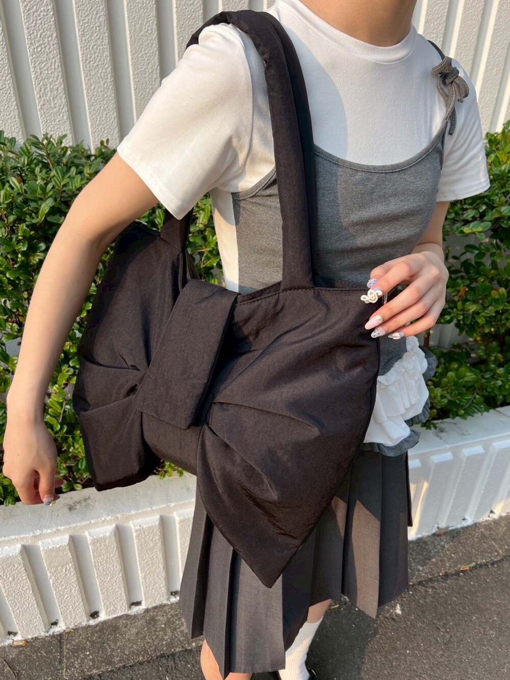 グレー系のTシャツ/カットソー、ブラック系のショルダーバッグ、ブラック系のシュシュを着用したレディースの春コーディネートの6枚目の写真