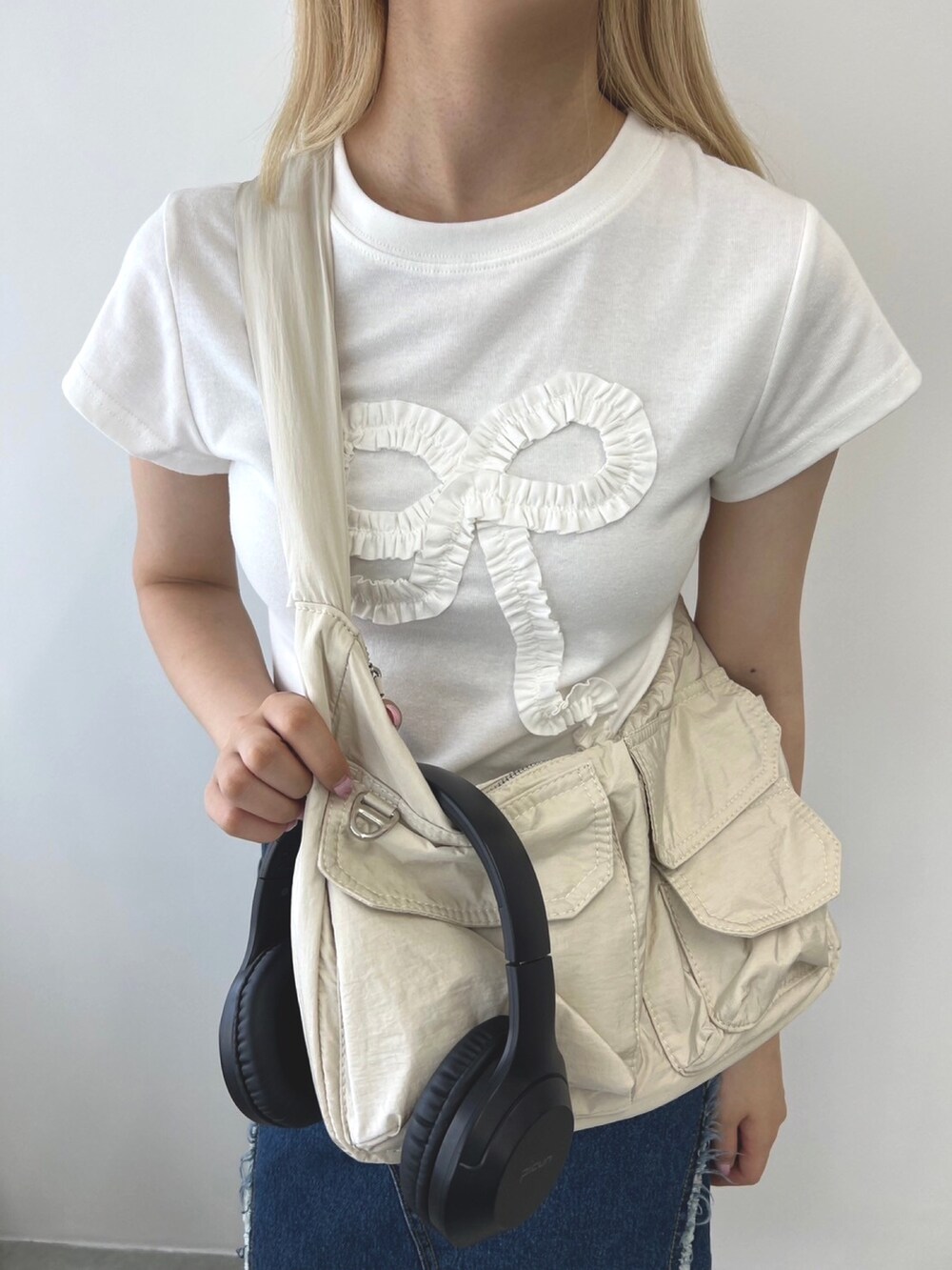 ホワイト系のショルダーバッグ、ブルー系のスカート、ホワイト系のTシャツ/カットソーを着用したレディースの夏コーディネートの3枚目の写真