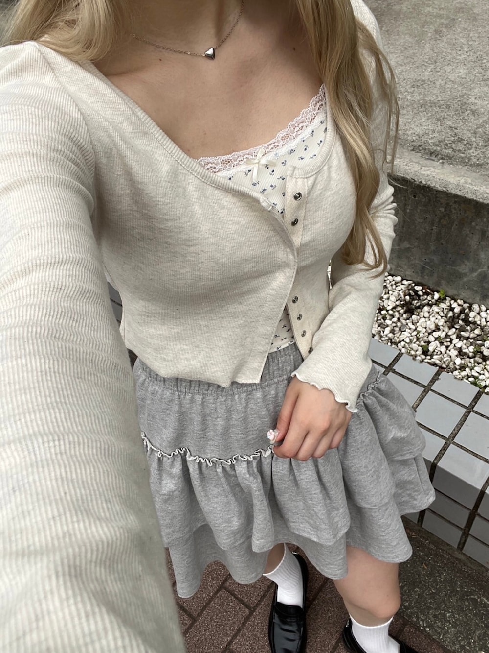 ホワイト系のTシャツ/カットソー、グレー系のスカート、ブラック系のショルダーバッグを着用したレディースの春コーディネートの3枚目の写真