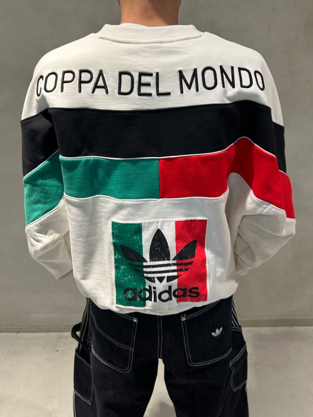 ブラック系のスニーカー、ホワイト系のスウェット、ブルー系のデニムパンツを着用したメンズの冬コーディネートの2枚目の写真