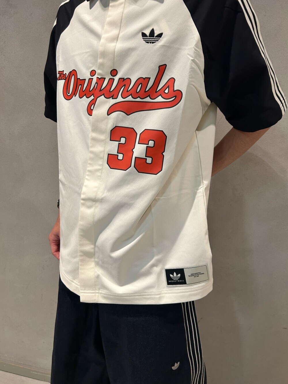 ホワイト系のシャツ/ブラウス、ブルー系のデニムパンツ、ブラック系のスニーカーを着用したメンズの夏コーディネートの2枚目の写真