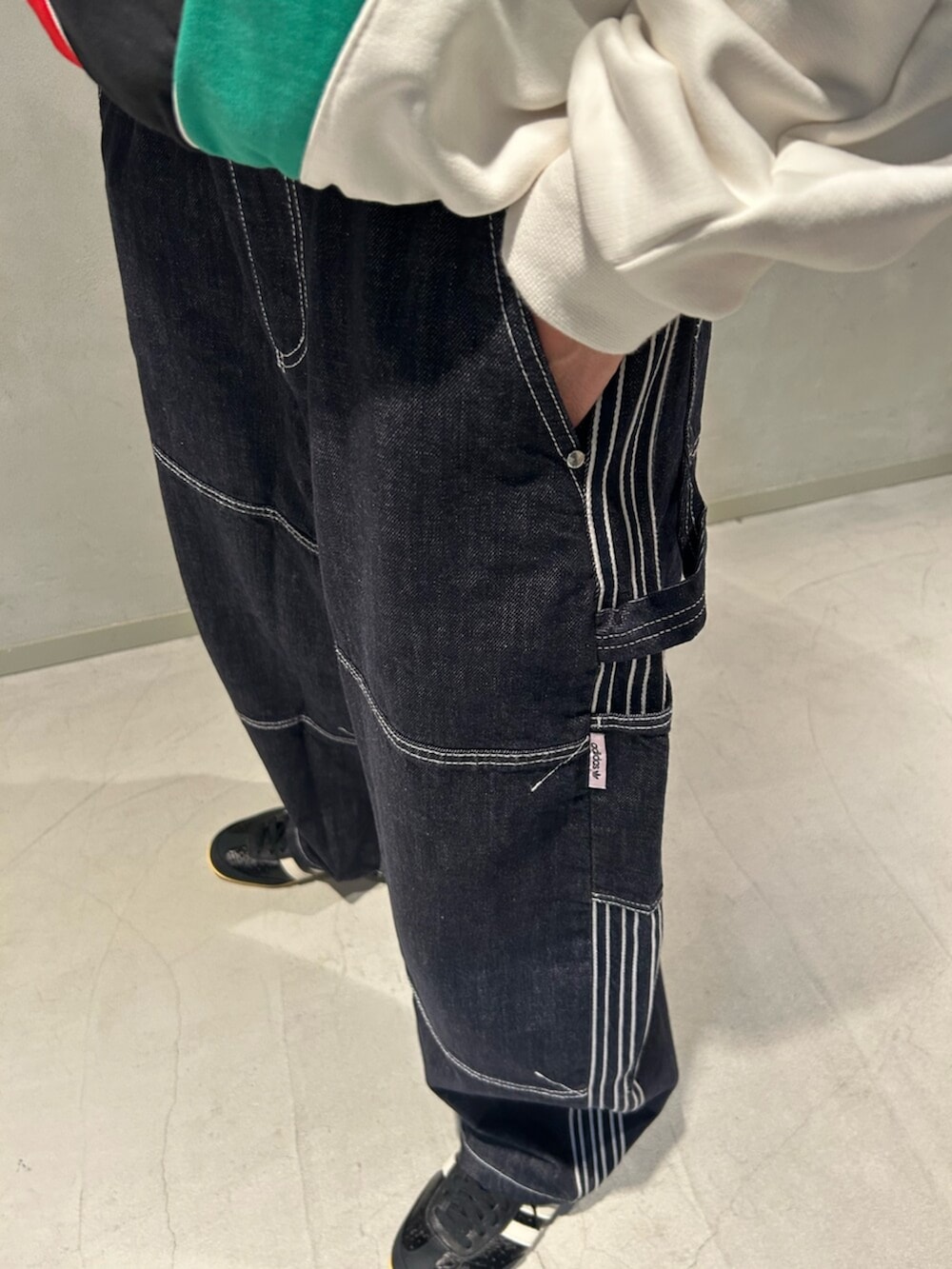 ブラック系のスニーカー、ホワイト系のスウェット、ブルー系のデニムパンツを着用したメンズの冬コーディネートの3枚目の写真