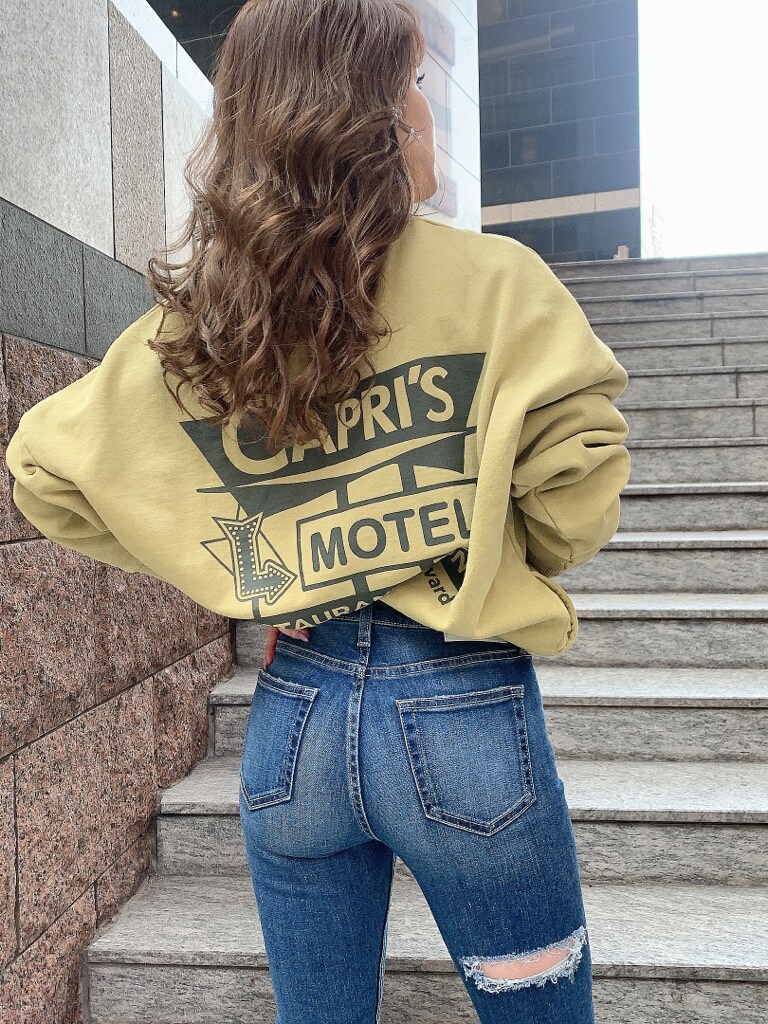 ホワイト系のパンプス、イエロー系のスウェットを着用したレディースの冬コーディネートの2枚目の写真