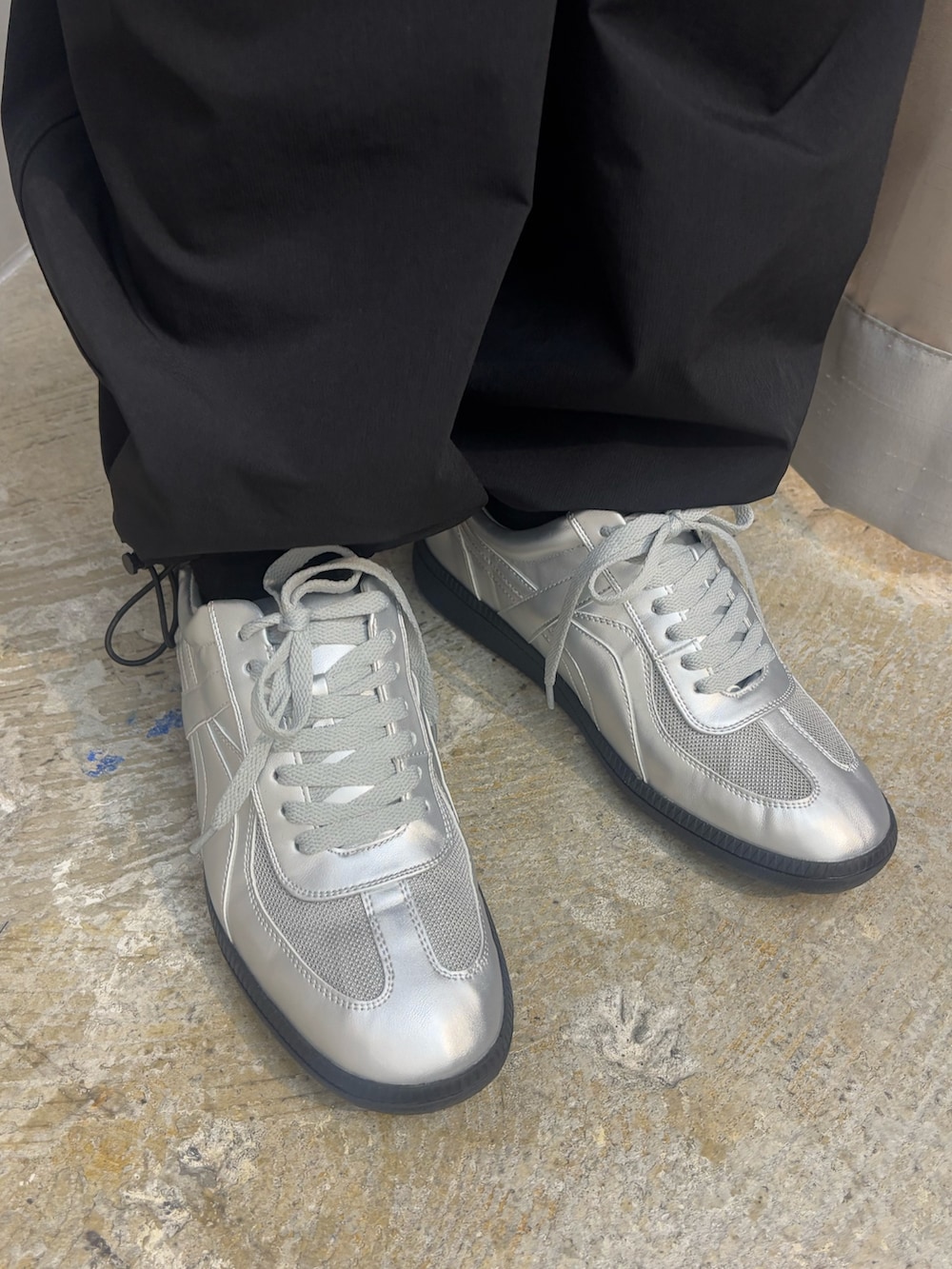 シルバー系のスニーカー、ブラック系のその他パンツ、ブラック系のTシャツ/カットソーを着用したレディースの春コーディネートの8枚目の写真