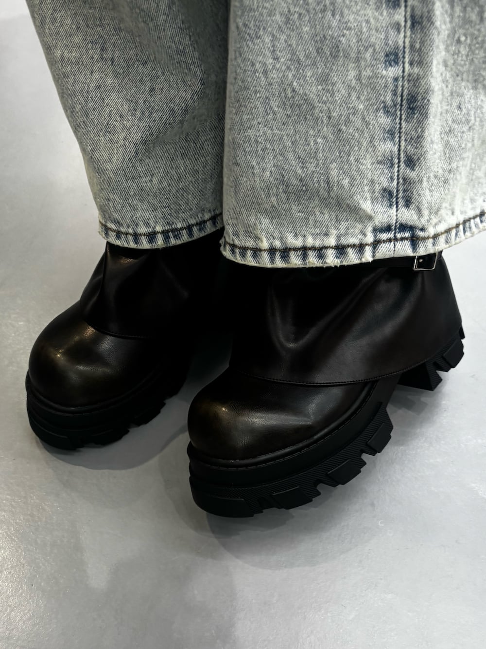 ブラック系のブーツ、ブルー系のデニムパンツ、グレー系のニット/セーターを着用したレディースの春コーディネートの6枚目の写真