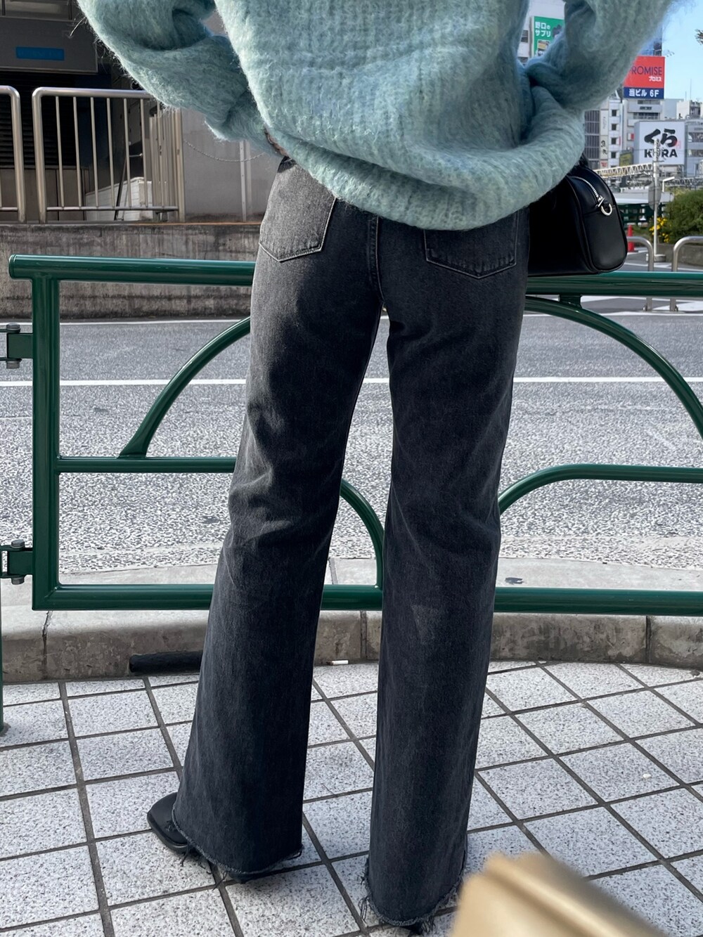 ブルー系のニット/セーター、ブラック系のデニムパンツ、ブラック系のブーツを着用したレディースの秋コーディネートの8枚目の写真