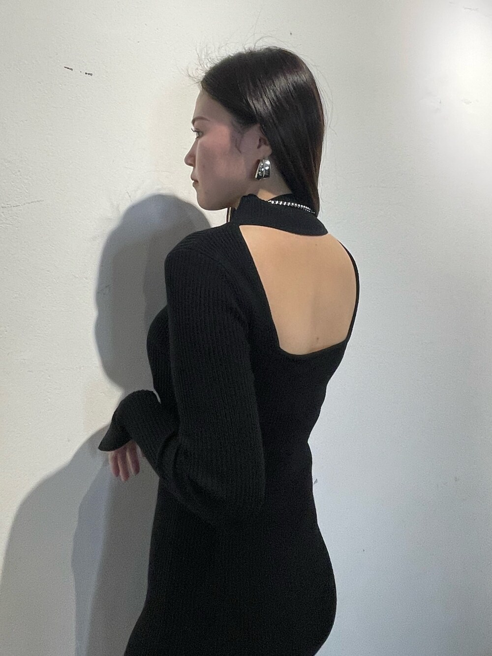 ブラック系のワンピース、ブラック系のパンプスを着用したレディースの冬コーディネートの5枚目の写真