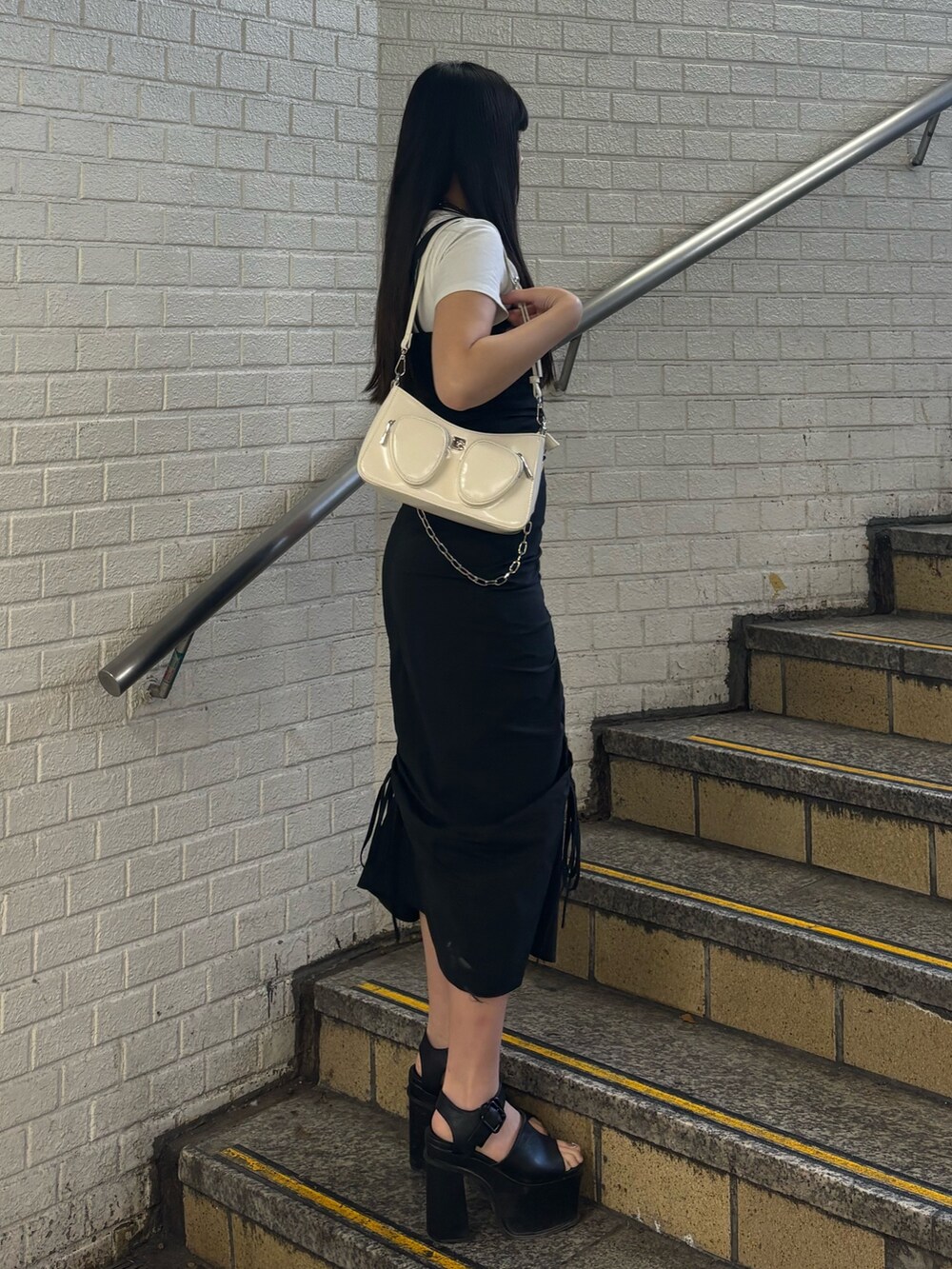 ブラック系のサンダル、ホワイト系のショルダーバッグ、ホワイト系のTシャツ/カットソーを着用したレディースの春コーディネートの2枚目の写真