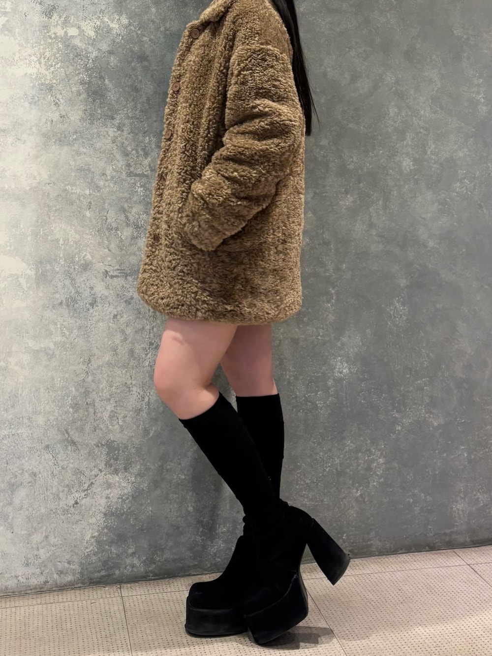 ブラック系のブーツ、ベージュ系のその他アウター、グレー系のワンピースを着用したレディースの冬コーディネートの2枚目の写真