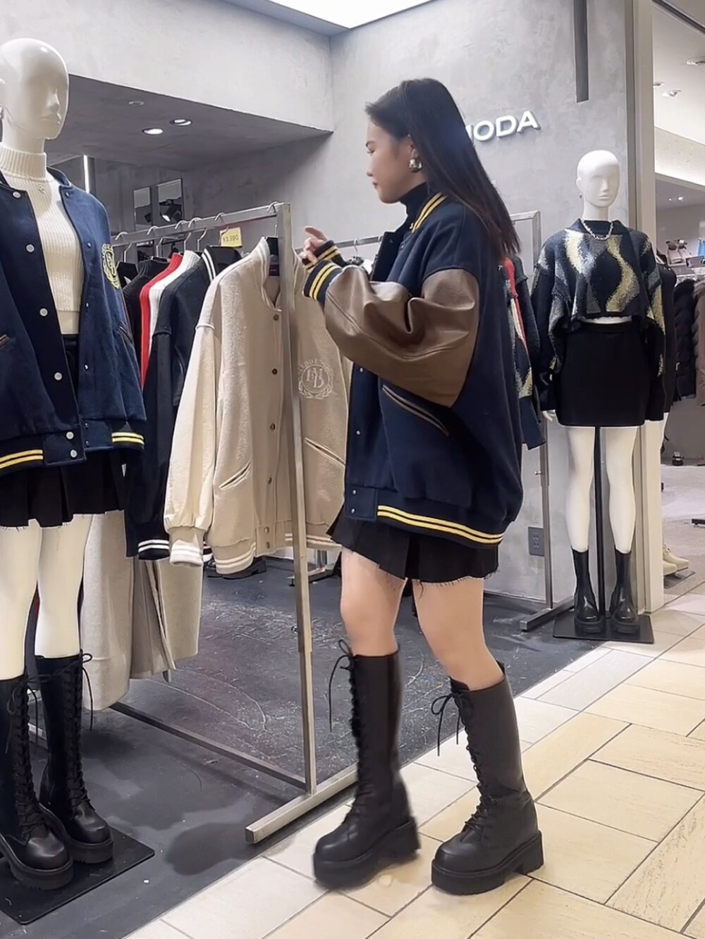 ブラック系のニット/セーター、ブラック系のスカート、ブルー系のブルゾンを着用したレディースの秋コーディネートの2枚目の写真