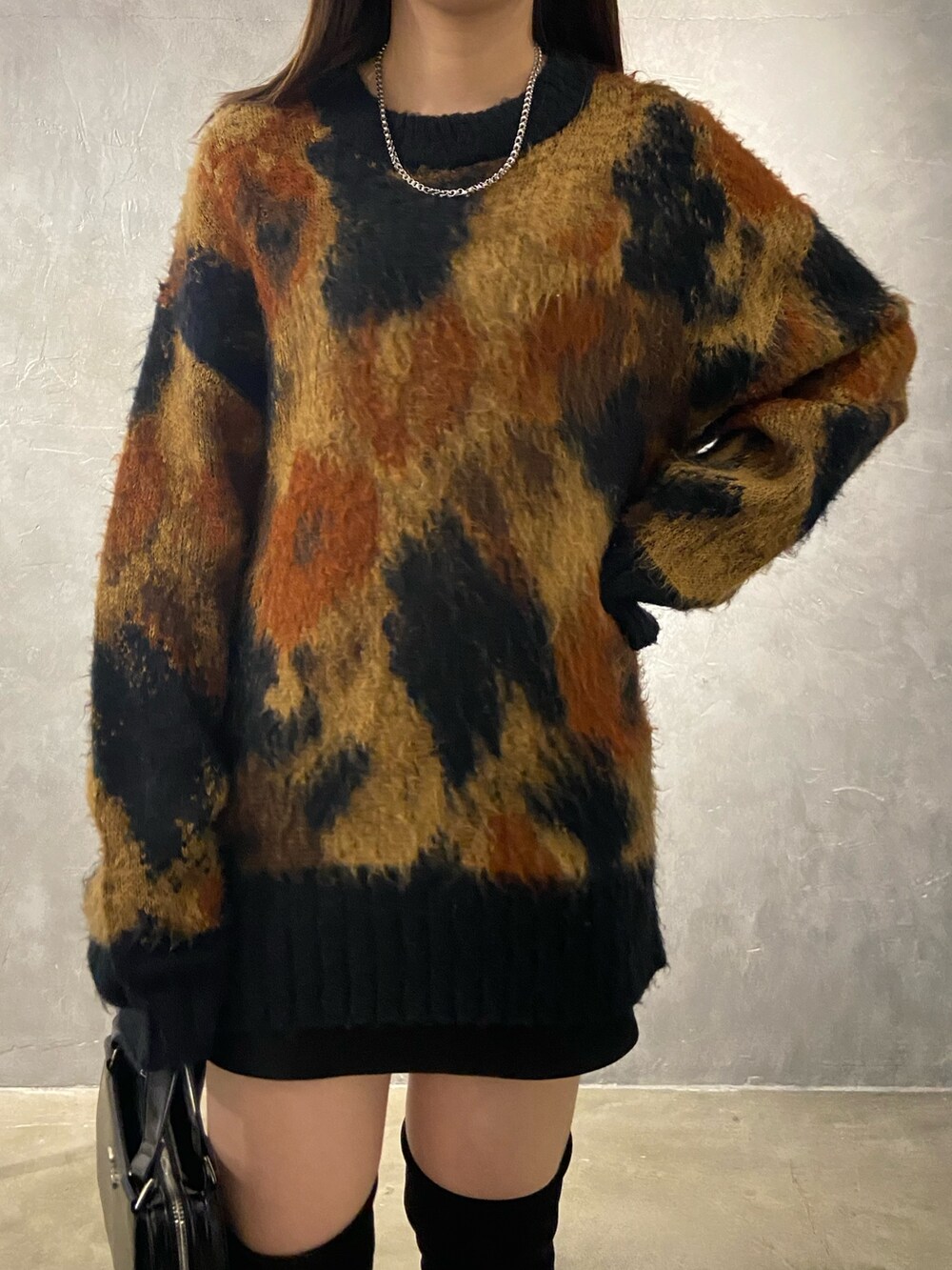 その他のニット/セーター、ブラック系のブーツ、ブラック系のハンドバッグを着用したレディースの秋コーディネートの4枚目の写真