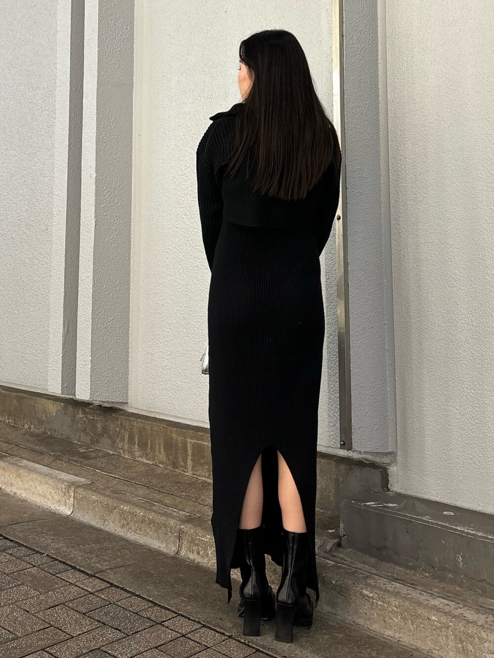 ブラック系のワンピース、ブラック系のブーツ、シルバー系のハンドバッグを着用したレディースの秋コーディネートの3枚目の写真